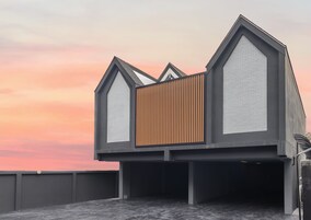 Un edificio moderno con un diseño arquitectónico único que incorpora elementos triangulares y paneles de madera.