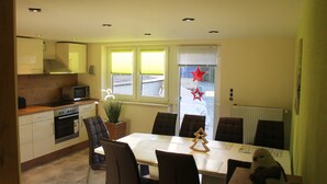 Una cocina moderna con comedor, que incluye una isla central, sillas y una mesa.