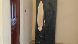 Une pièce avec une armoire de couleur sombre, une porte en bois et un mur de couleur beige.