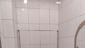 Een kleine, functionele badkamer met toilet, wastafel en spiegel.