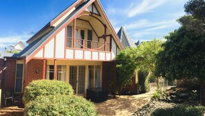 A two-story house with a prominent gable roof, a front porch, and a small garden area. - The Heart of Geelong (Geelong)