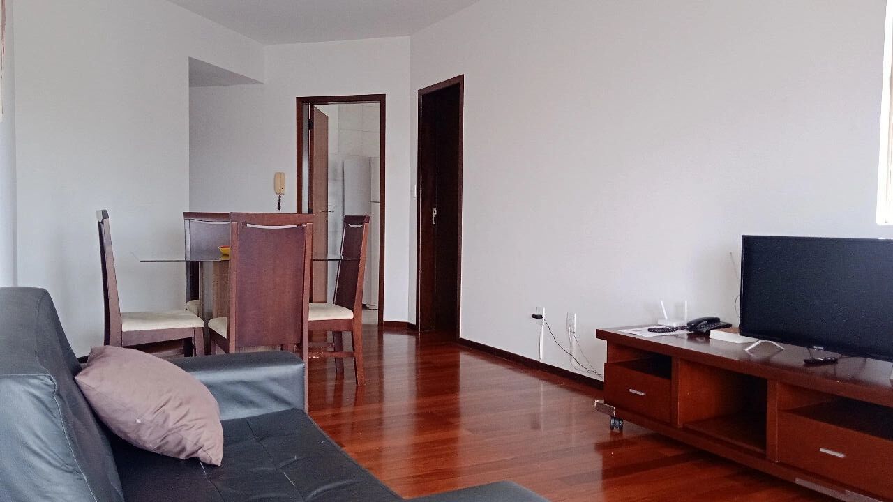 Een moderne woonkamer met een bank, tv-meubel en houten meubels.