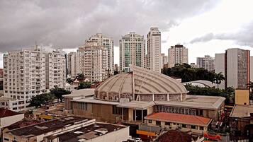 A large, historic building with a prominent dome and arched windows, surrounded by modern high-rise buildings.