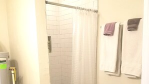 Une salle de bain avec douche, toilettes et lavabo.