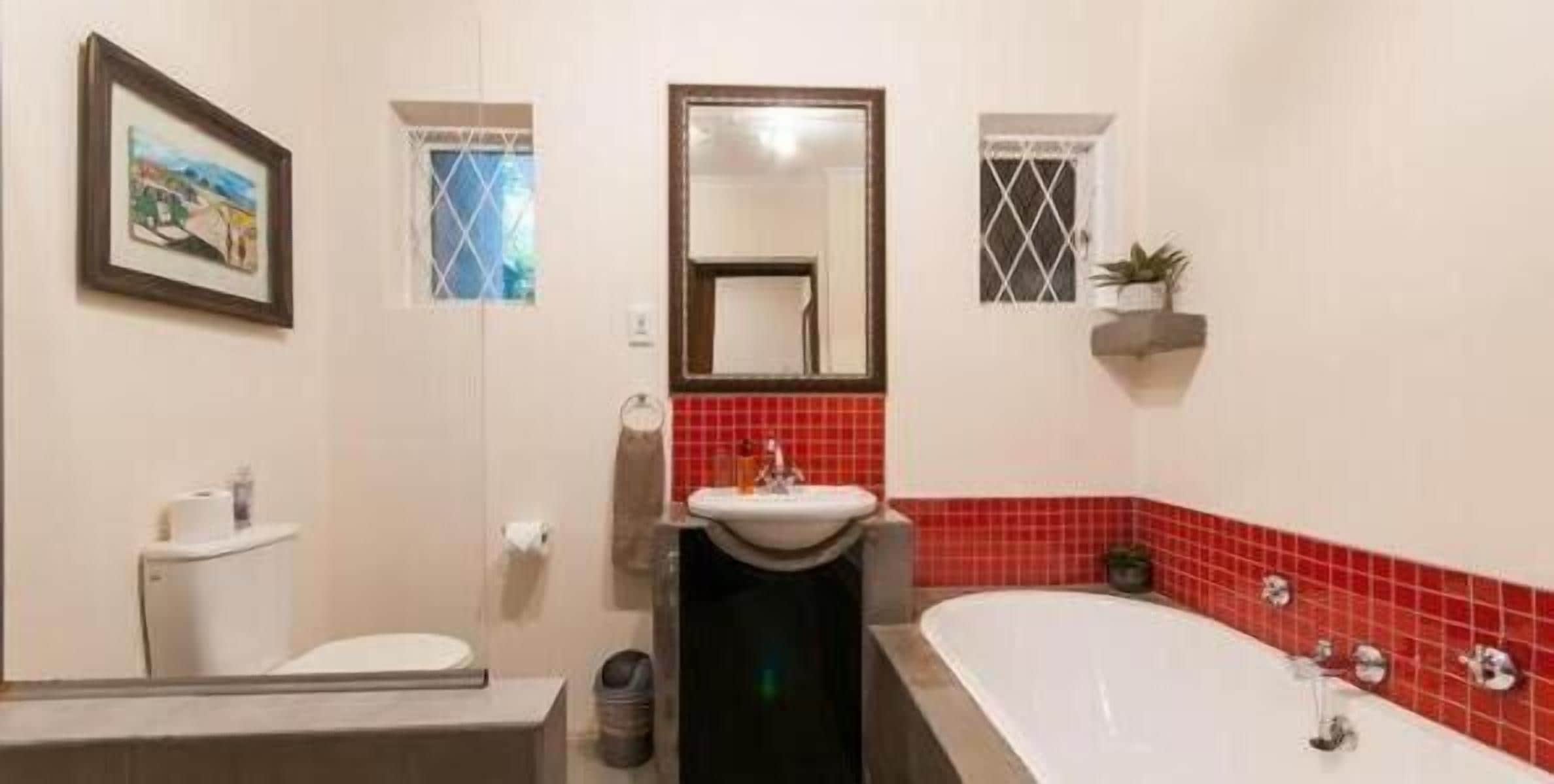 A bathroom with a toilet, sink, and bathtub.