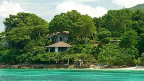 A beachfront property with a large house surrounded by dense greenery and a clear turquoise sea. - Bluefields Bay Villas (Bluefields)
