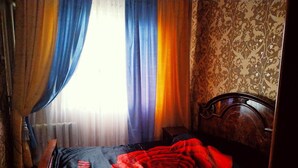A bedroom with a bed, a wooden headboard, and a window with curtains. - Welcome Home 7 (Tashkent)