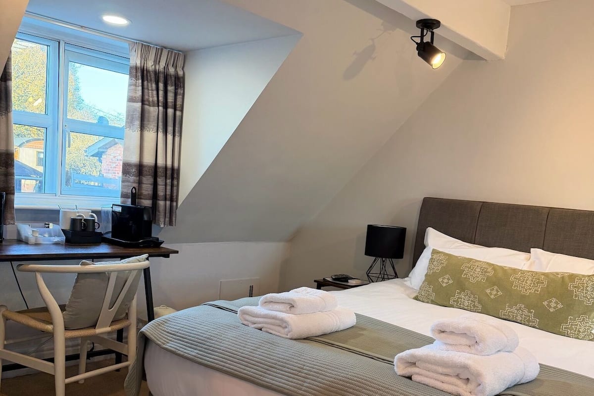 Une chambre à coucher avec un lit, un bureau et une fenêtre.