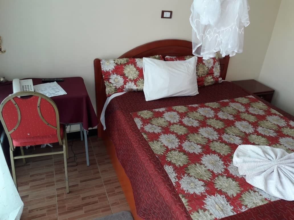 A hotel room with a bed, a desk, and a chair.
