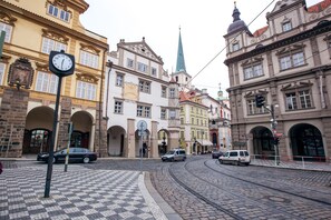 Une rue historique, avec ses pavés, ses rails de tramway et son architecture européenne typique.