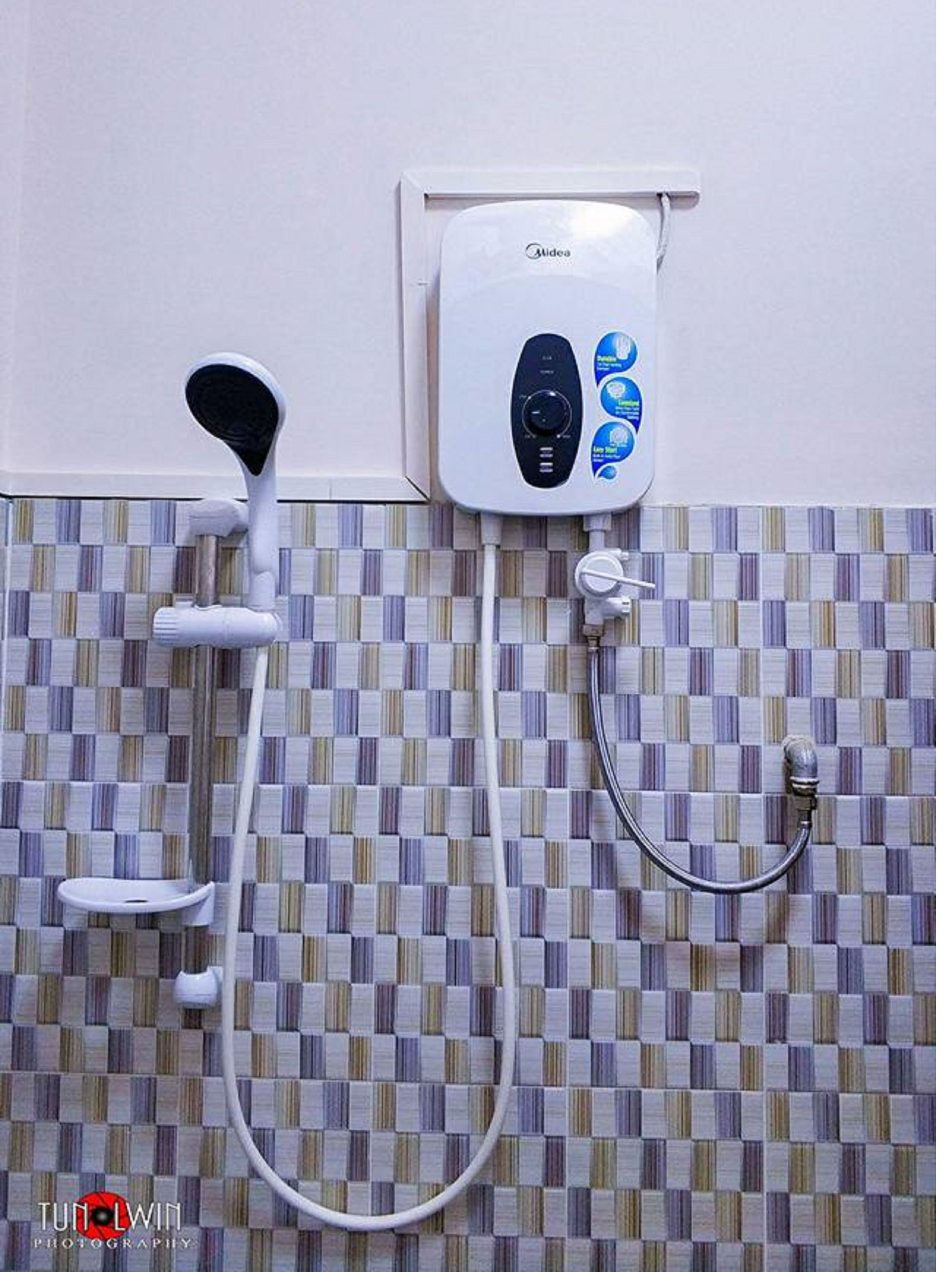 Un baño con ducha empotrada, cabezal de ducha manual y rociador de mano.