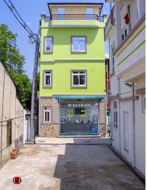 A two-story building with a green facade and a welcoming sign. - Hein Motel (Meiktila)