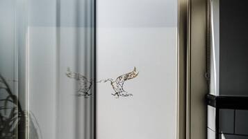 Een raam met een kunstwerk waarop twee vogels in de vlucht staan afgebeeld.