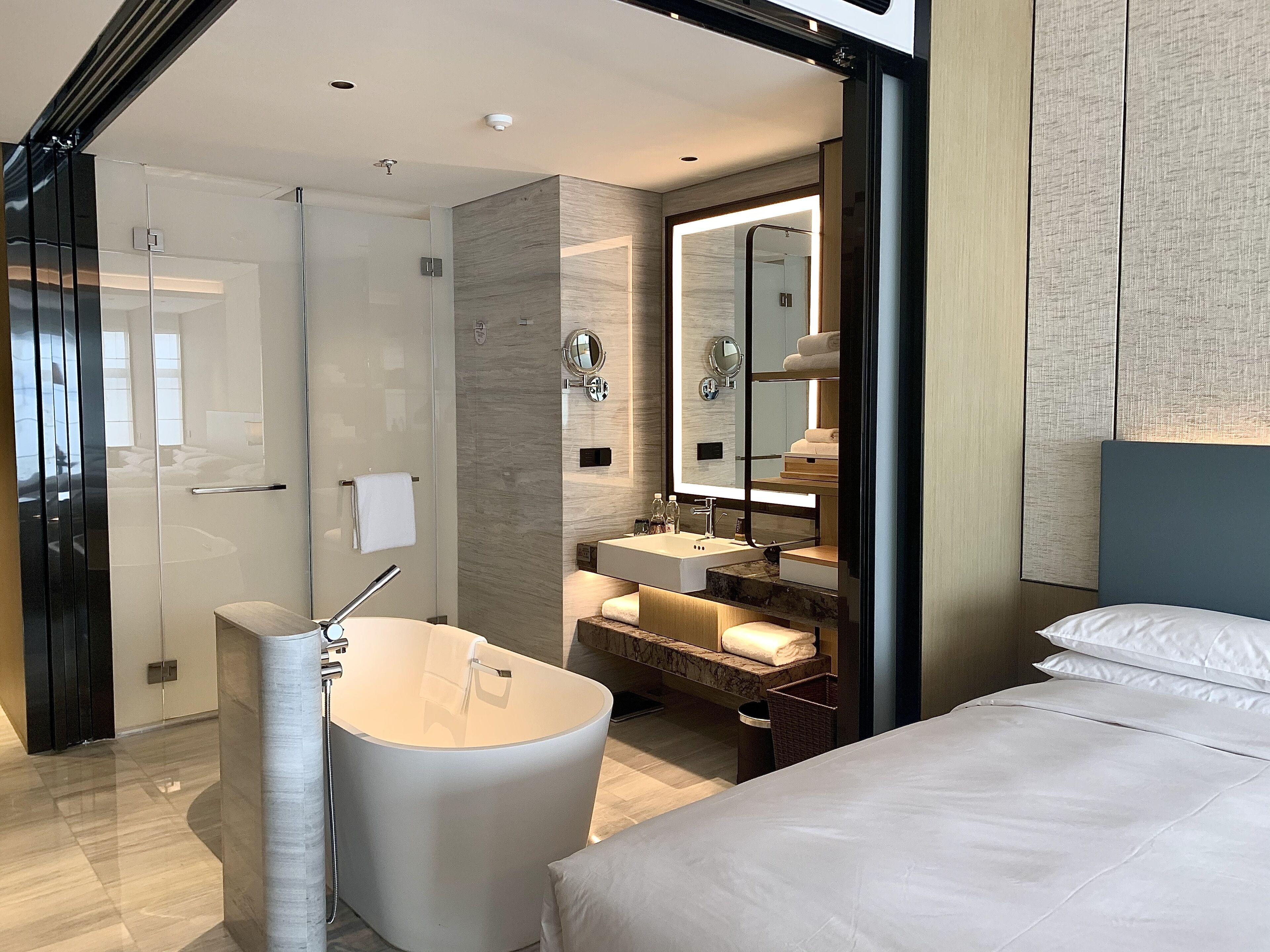 A modern bathroom with a freestanding bathtub, a glass shower enclosure, and a vanity with a mirror.