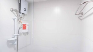 Een moderne badkamer met een inloopdouche, een handdouche en een bedieningspaneel aan de muur.