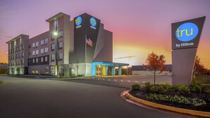 A modern hotel with a prominent 'TRU by Hilton' sign, multiple floors, and a well-lit entrance. - Tru By Hilton Chattanooga Hamilton Place (Chattanooga)