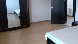 A bedroom with a bed, a wardrobe, and a mirror.