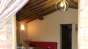 Un comedor con una mesa de madera, sillas y un sofá rojo.