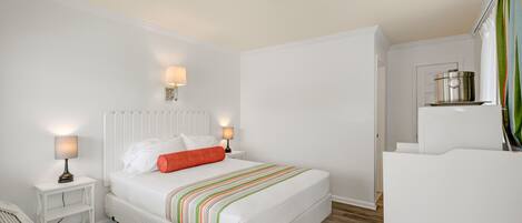 A neatly arranged bedroom with a bed, bedside tables, and a nightstand.