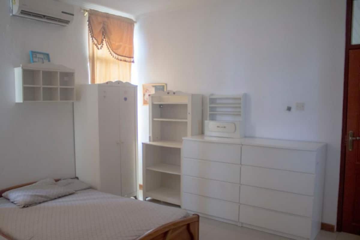 Ein Schlafzimmer mit einem Bett, einem Kleiderschrank und einer Kommode.