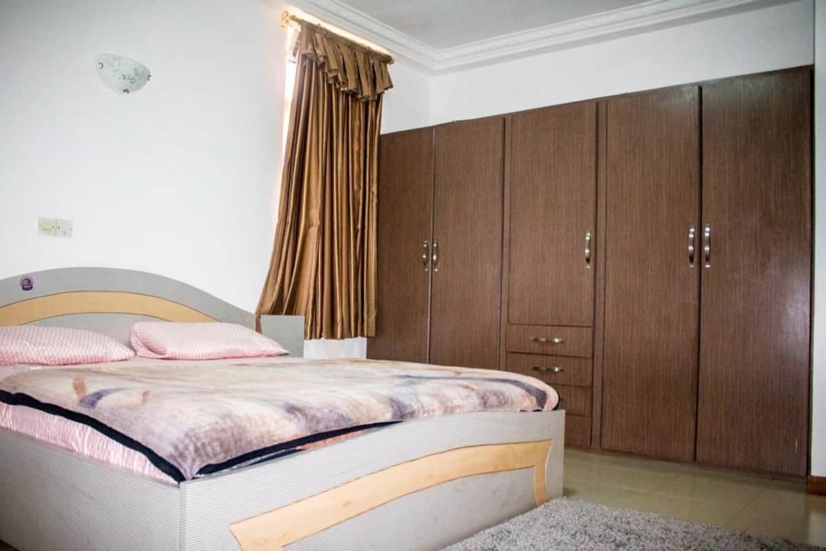 Ein Schlafzimmer mit einem Bett, einem Kleiderschrank und einem Vorhang.