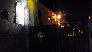 Un edificio de ladrillo con una reja de metal y dos luces esféricas iluminadas.
