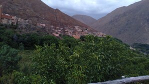A mountainous village with terraced buildings and a prominent mosque. - Tanssi House (Asni)