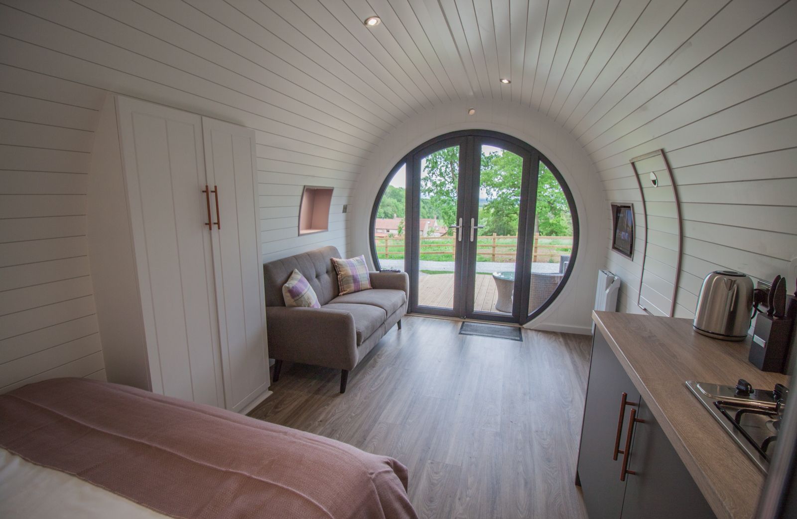 Una camera accogliente con un letto, un divano e un'ampia finestra ad arco.