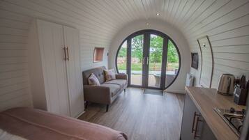 Una camera accogliente con un letto, un divano e un'ampia finestra ad arco.