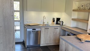 A modern kitchen with a dishwasher, sink, and wooden cabinets.