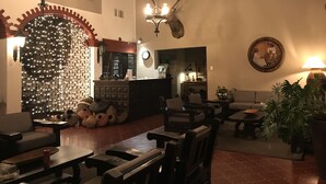 A cozy restaurant interior with wooden furniture, a decorative deer head, and a wall-mounted clock. - Parador del Alma (Bocoyna)
