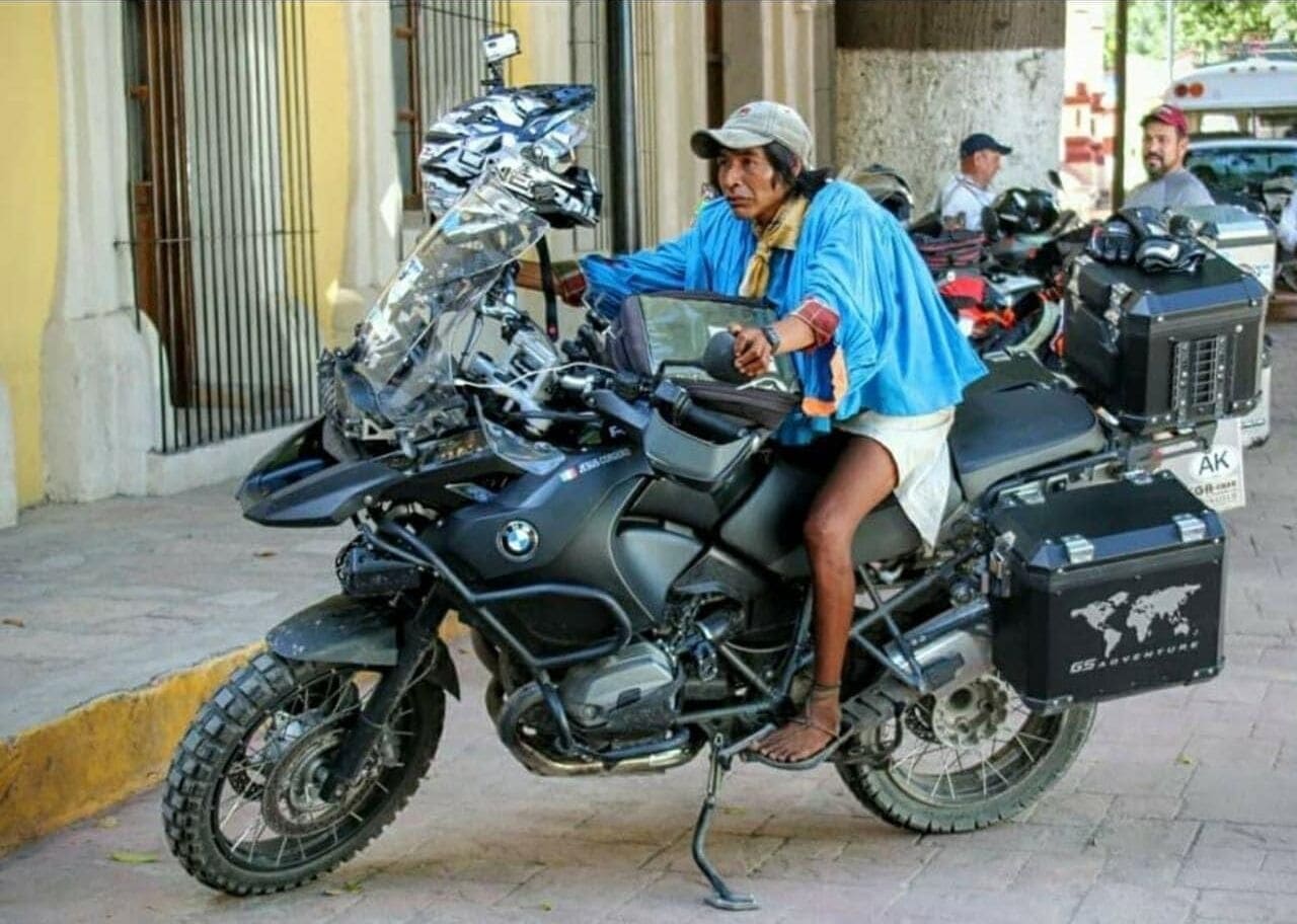 Eine Person sitzt auf einem Motorrad mit Gepäckträger.