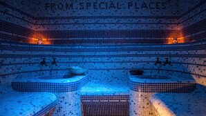 Ein Wellnessbereich mit Wandfliesen aus Mosaik und drei Sitzbereichen.