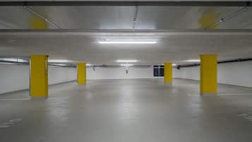 Eine Parkgarage mit Betonböden und gelben Säulen.