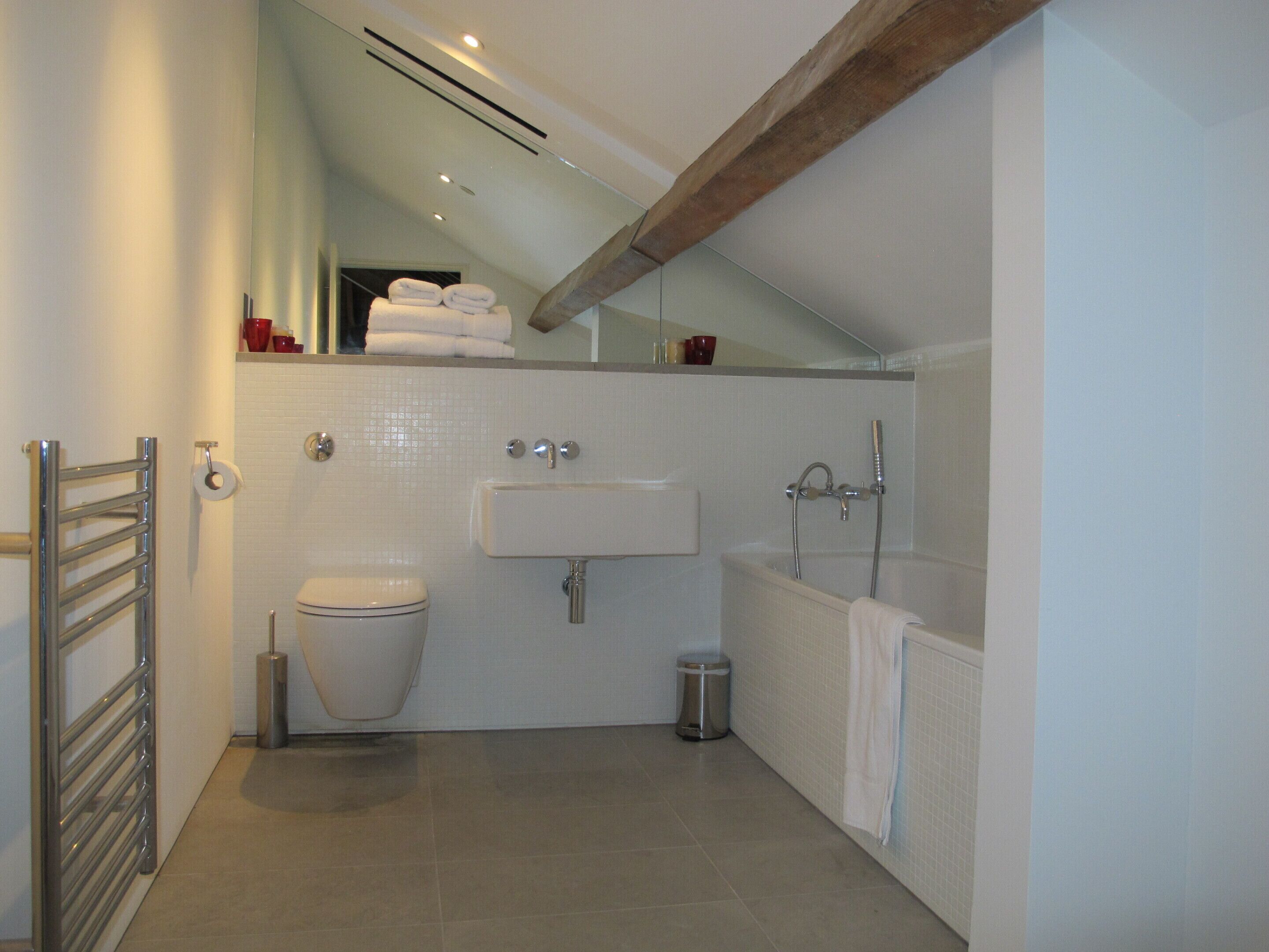 A modern bathroom with a toilet, sink, and bathtub.
