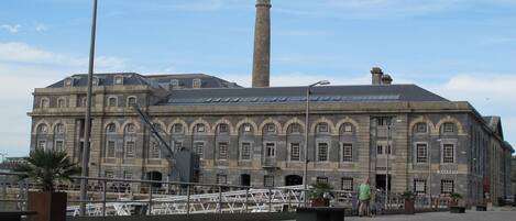 Un grand bâtiment historique doté d’une tour imposante et de fenêtres en arc de cercle.