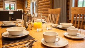 A breakfast table set with white dishes, a coffee pot, and glasses of orange juice.