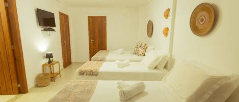 Una habitación de hotel con dos camas, televisión, lámpara y decoración mural.