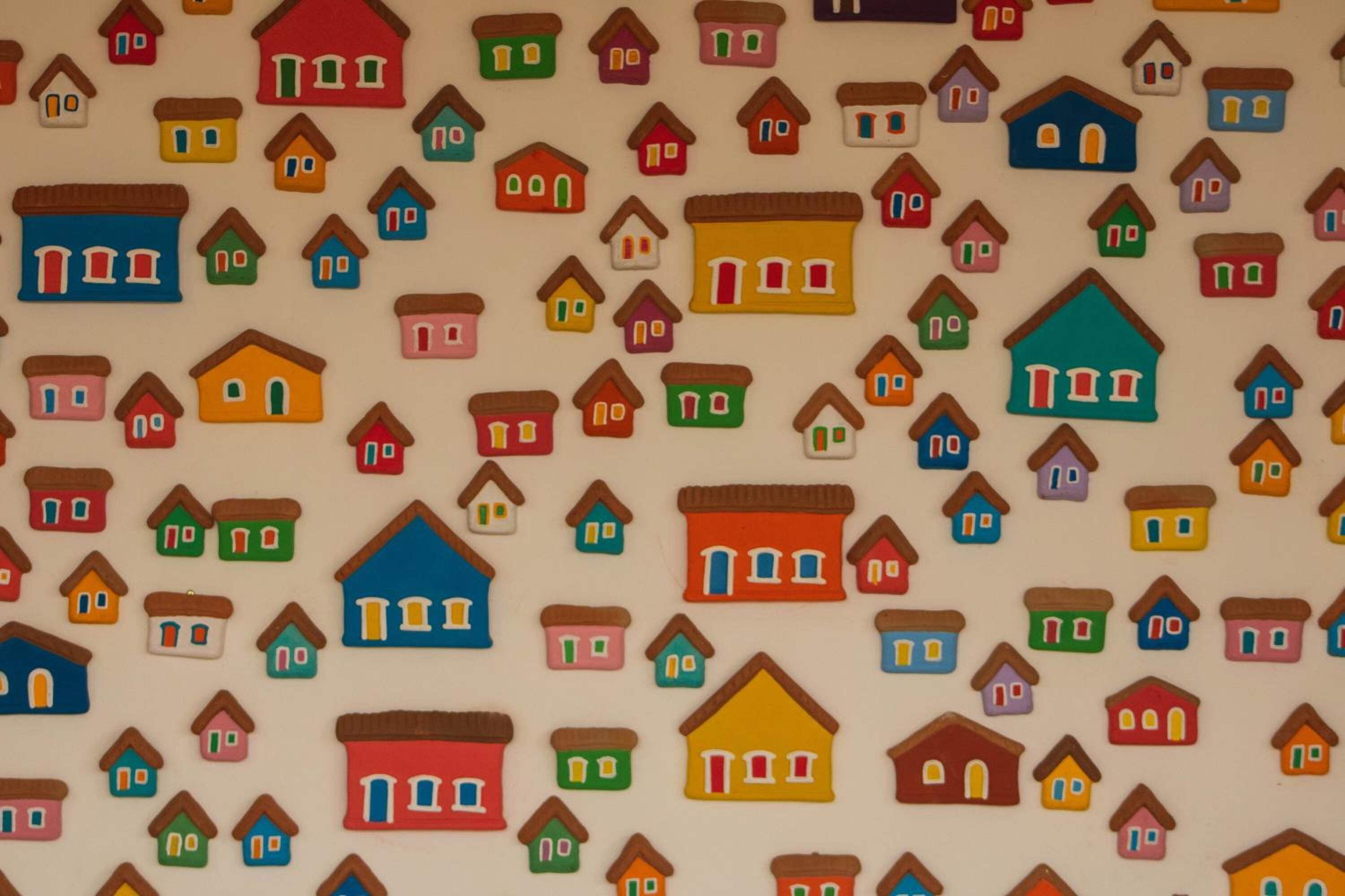 A pattern of variously colored houses on a plain background.