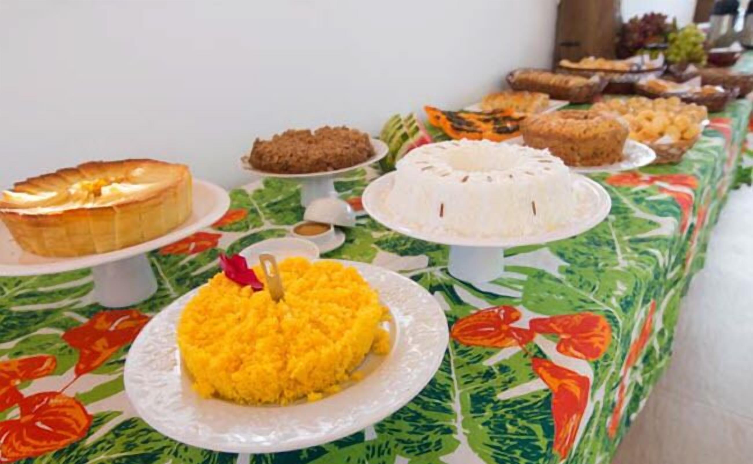 A buffet table with various dishes including a yellow rice dish, a white rice dish, and several desserts.