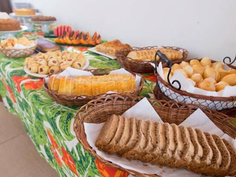 Ein reichhaltiges Buffet mit verschiedenen Speisen, darunter Brot, Gebäck und Obst.