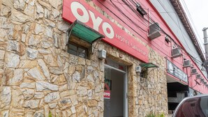 Een hotel genaamd "Oyo Hotel San Pedro" met een gevel van steen en een rood bord.