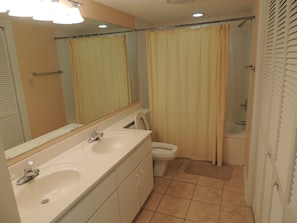A bathroom with two sinks, a toilet, and a shower. - Windermere by the Sea #2A (Myrtle Beach)