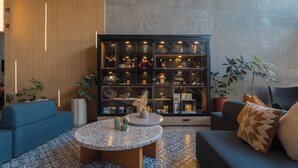 A modern living room with a round coffee table, blue sofas, and a large cabinet filled with decorative items.