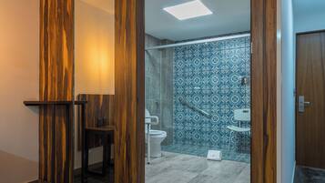 Un baño moderno con una pared de acento de madera, cabina de ducha de vidrio y salpicadero con azulejos estampados.