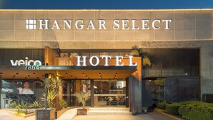 A modern hotel entrance with a large sign reading "HANGAR SELECT HOTEL" and "veico 864".