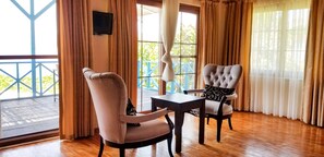 Habitación Deluxe, balcón, vista al mar | Área de sala de estar | Televisión LCD