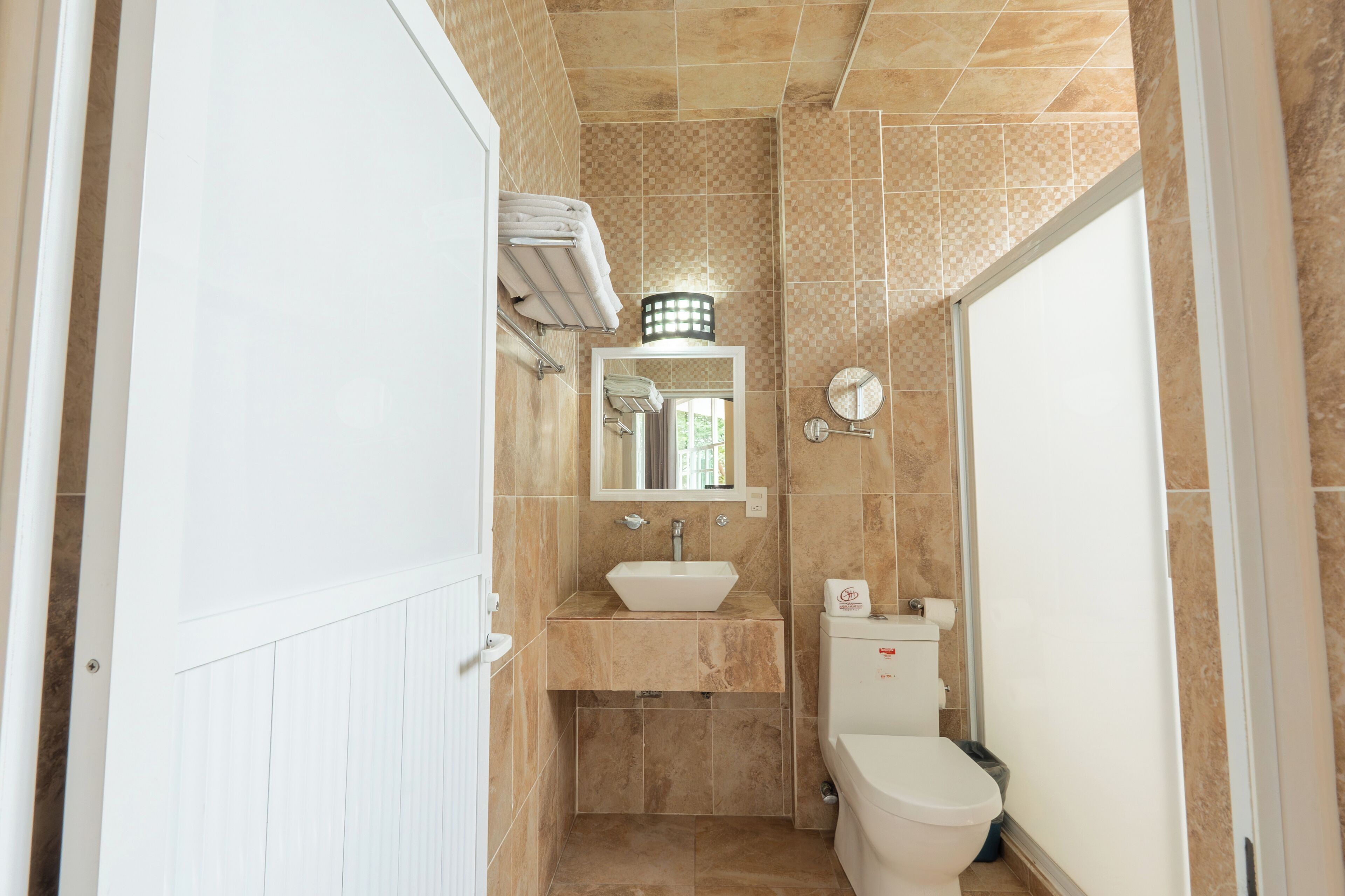A bathroom with a white sink, a toilet, and a mirror above the sink.