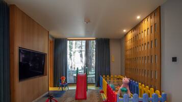 A modern children's play area with a TV, slide, and play structures.