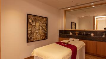Relax in a serene space with a comfortable bed, a cabinet, and a large artwork above.